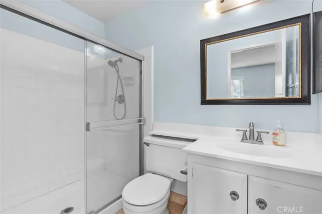 a bathroom with a toilet a sink a vanity and mirror