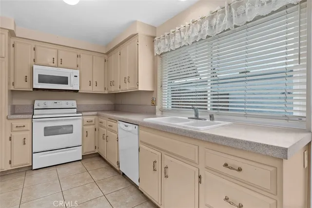a kitchen with granite countertop white cabinets and white appliances