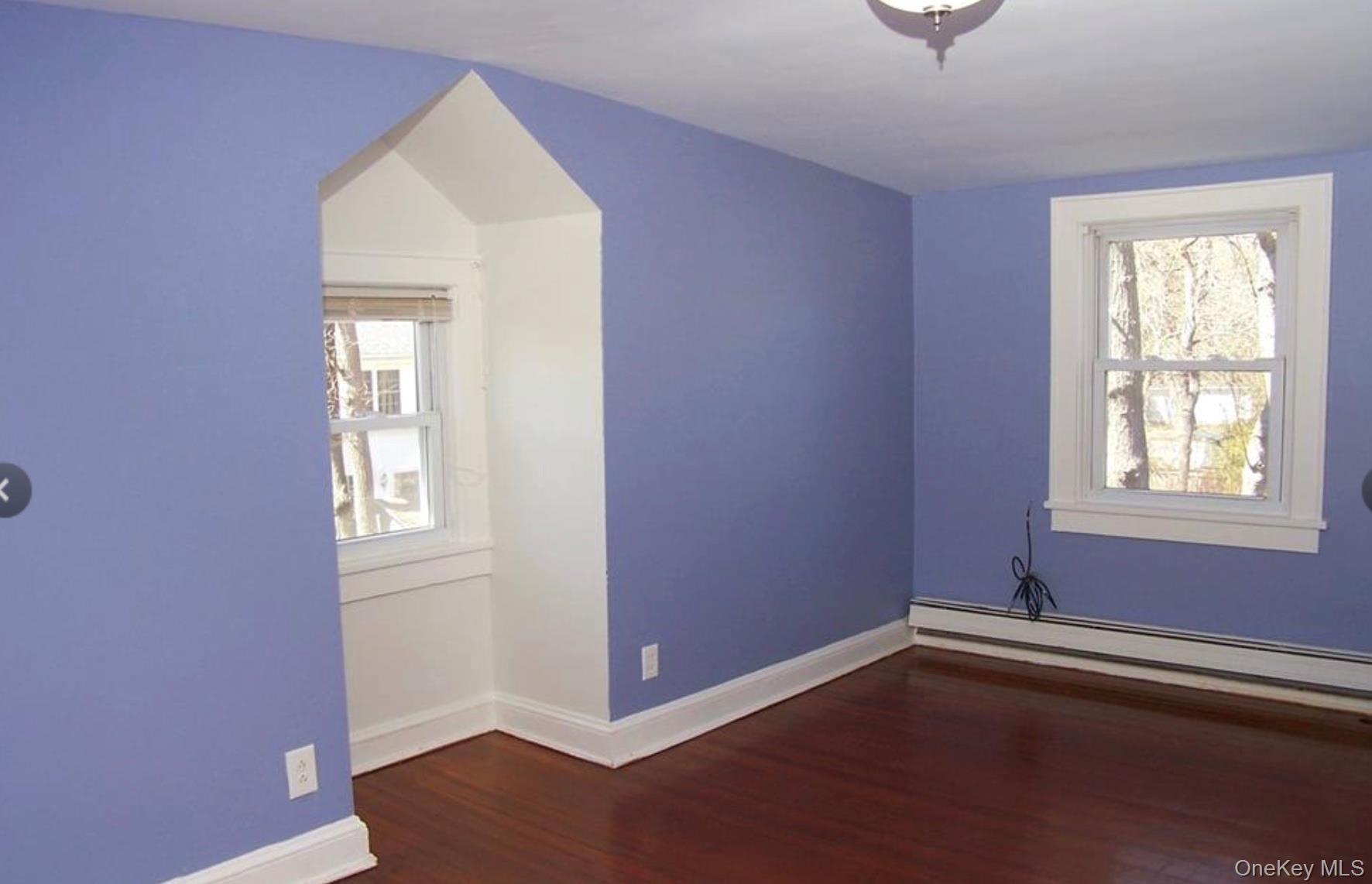 36 Columbine Road Rocky Point, NY 11778 - Photo 11 of 14 Additional living space with dark wood-style floors, plenty of natural light, and baseboard heating
