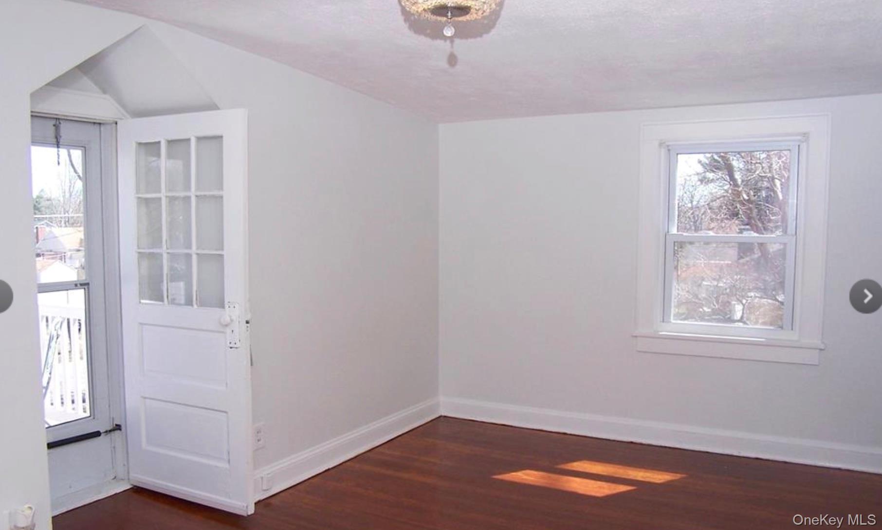 36 Columbine Road Rocky Point, NY 11778 - Photo 12 of 14 Spare room featuring healthy amount of natural light, dark wood-type flooring, and a textured ceiling