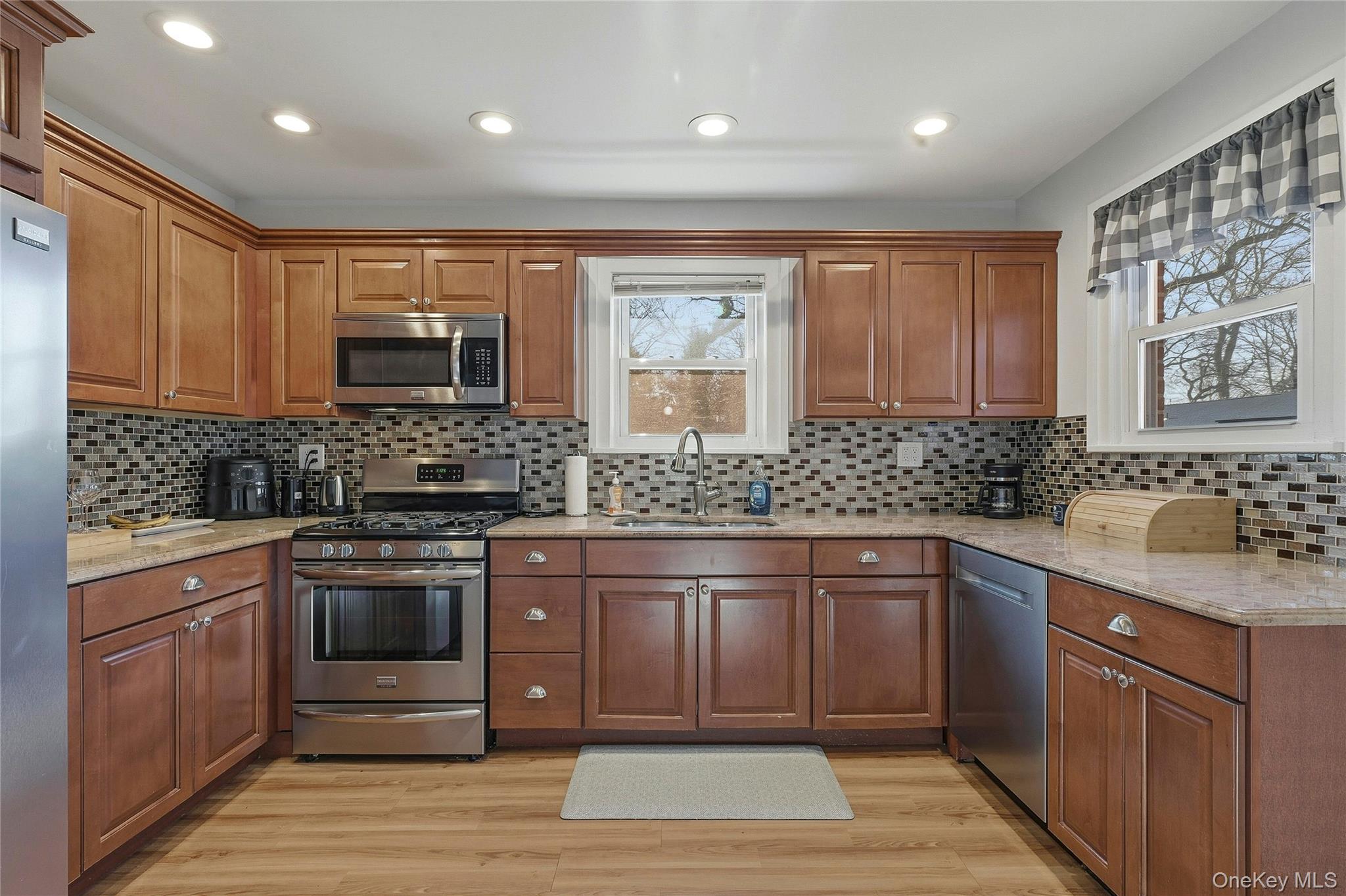 36 Columbine Road Rocky Point, NY 11778 - Photo 17 of 37 a kitchen with stainless steel appliances granite countertop wooden cabinets a sink and dishwasher a stove with wooden floor