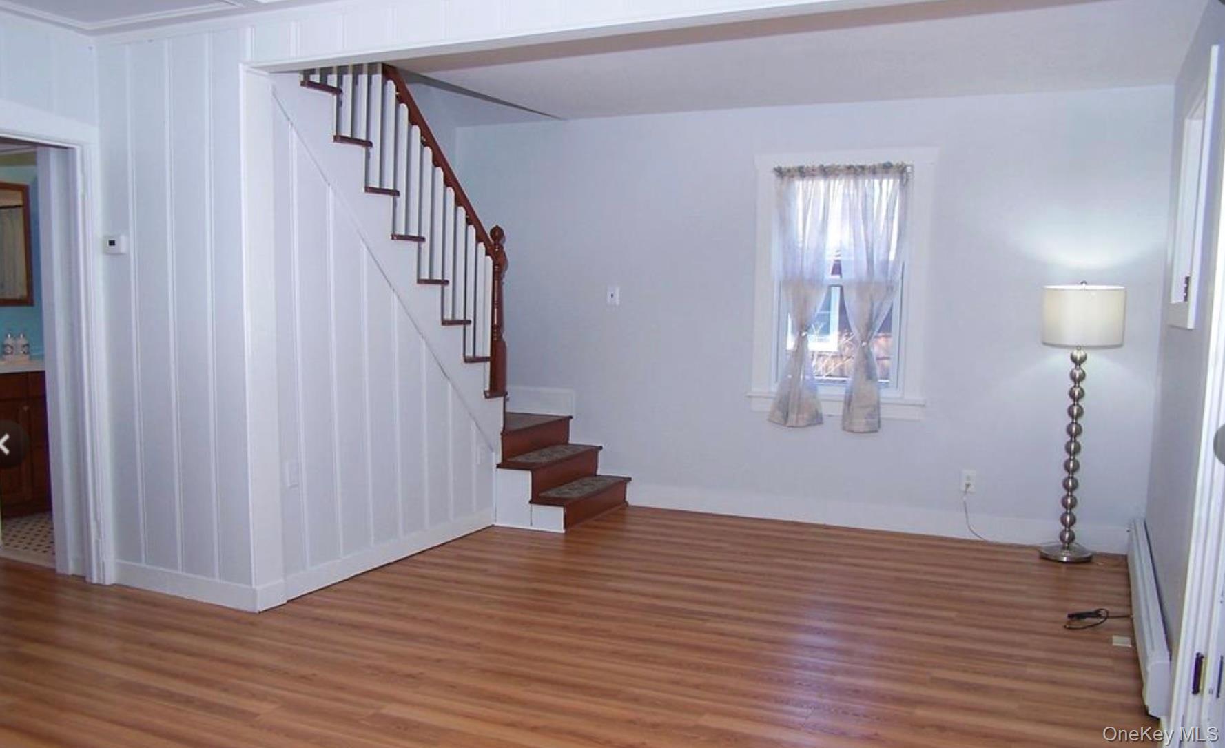 36 Columbine Road Rocky Point, NY 11778 - Photo 4 of 14 Stairway featuring wood finished floors and a baseboard heating unit