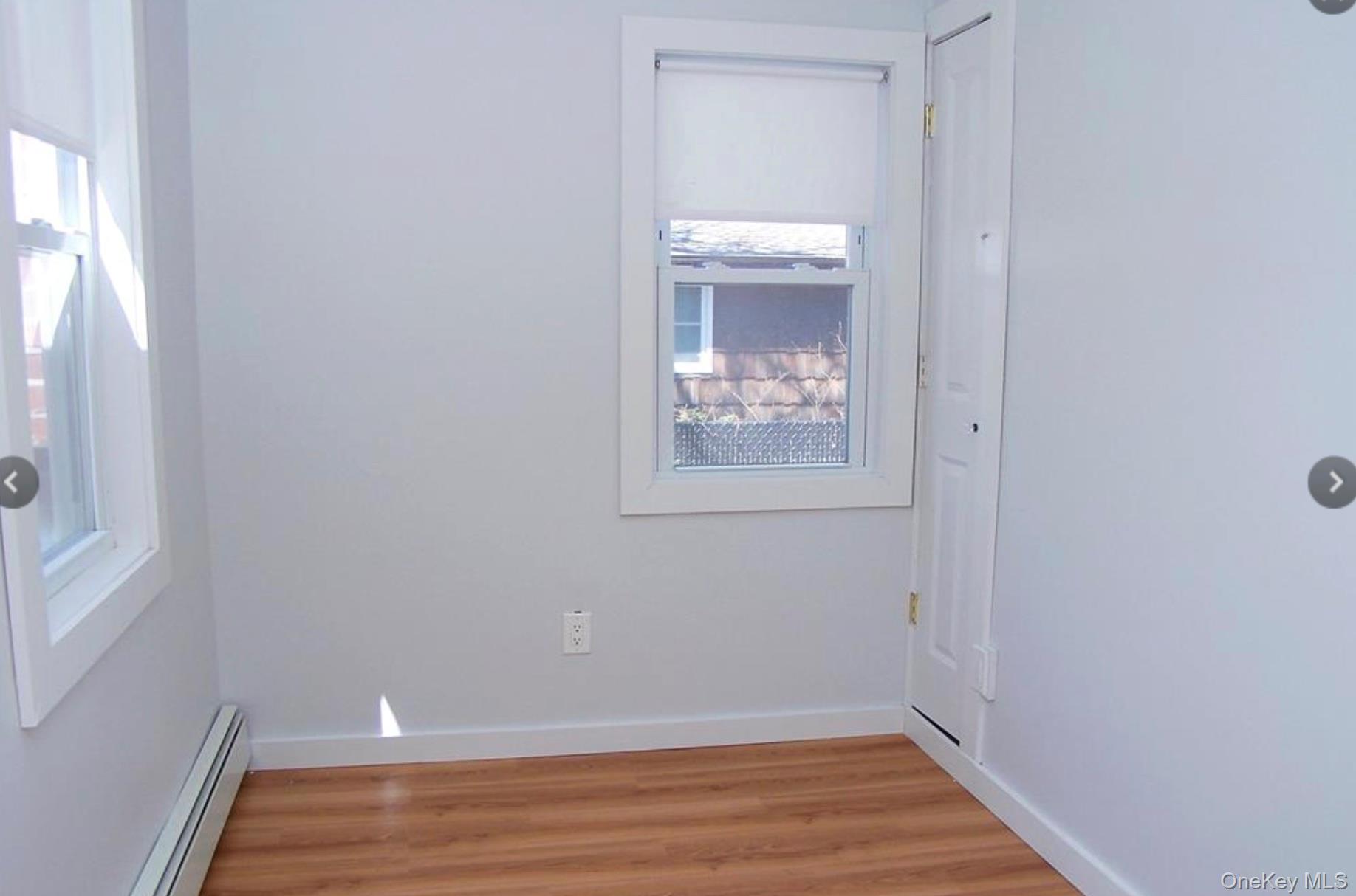 36 Columbine Road Rocky Point, NY 11778 - Photo 7 of 14 Unfurnished room with a baseboard heating unit and light wood-type flooring