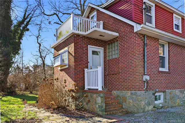 a view of a brick house with a large windows and flower plants