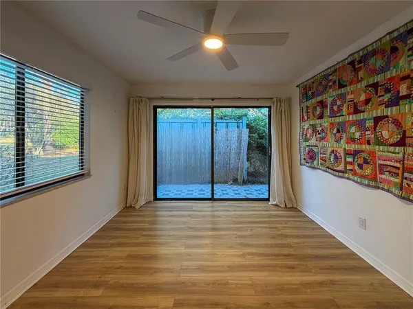 a view of an empty room with window and wooden floor