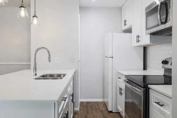 a kitchen with stainless steel appliances a sink a stove a refrigerator and cabinets