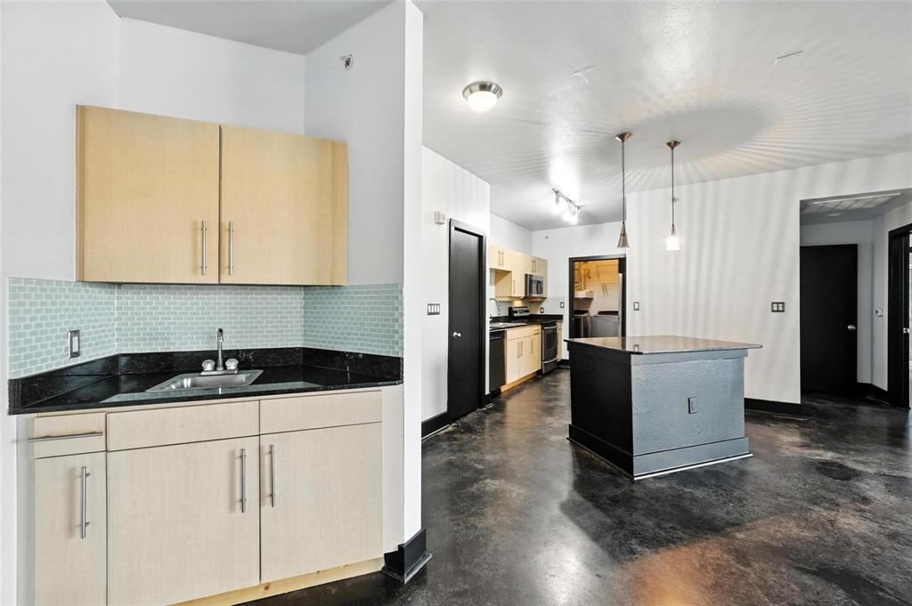 4414 Cedar Springs Road, Unit 124 Dallas, TX 75219 - Photo 4 of 20 a kitchen with granite countertop a sink and a refrigerator