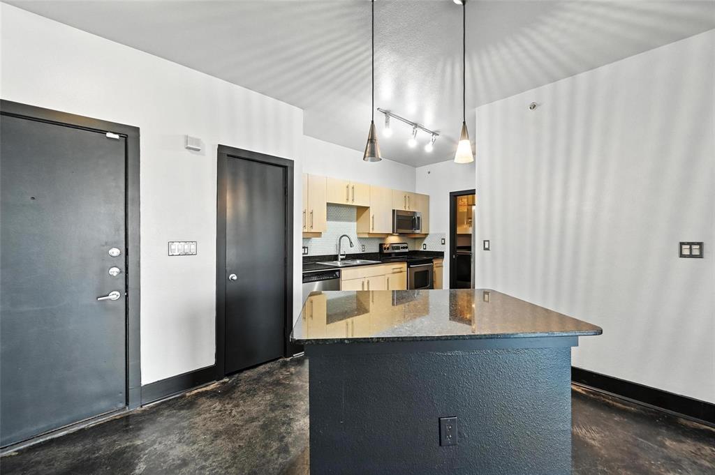 4414 Cedar Springs Road, Unit 124 Dallas, TX 75219 - Photo 5 of 20 a kitchen with stainless steel appliances granite countertop a refrigerator a sink and a stove