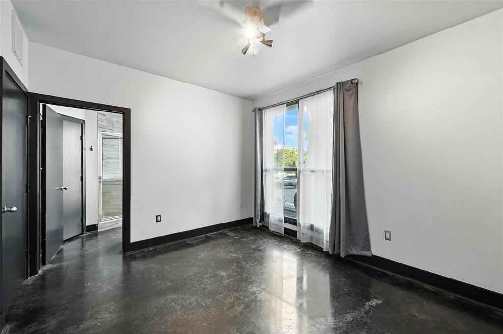 4414 Cedar Springs Road, Unit 124 Dallas, TX 75219 - Photo 9 of 20 an empty room with wooden floor and a ceiling fan