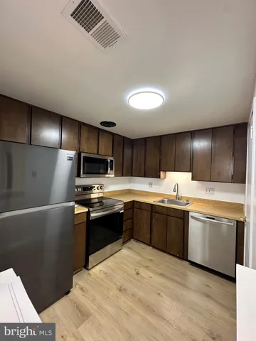 a kitchen with stainless steel appliances granite countertop a sink and stove top oven