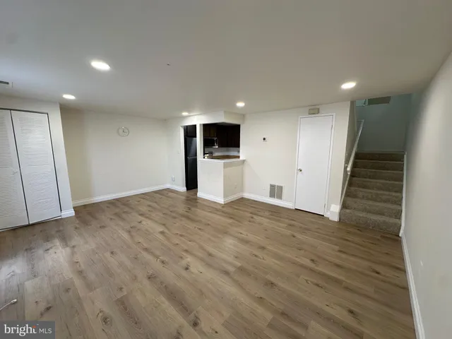 a view of empty room with wooden floor
