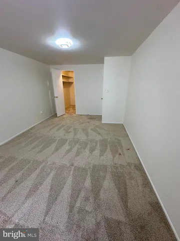 an empty room with a ceiling fan and a window