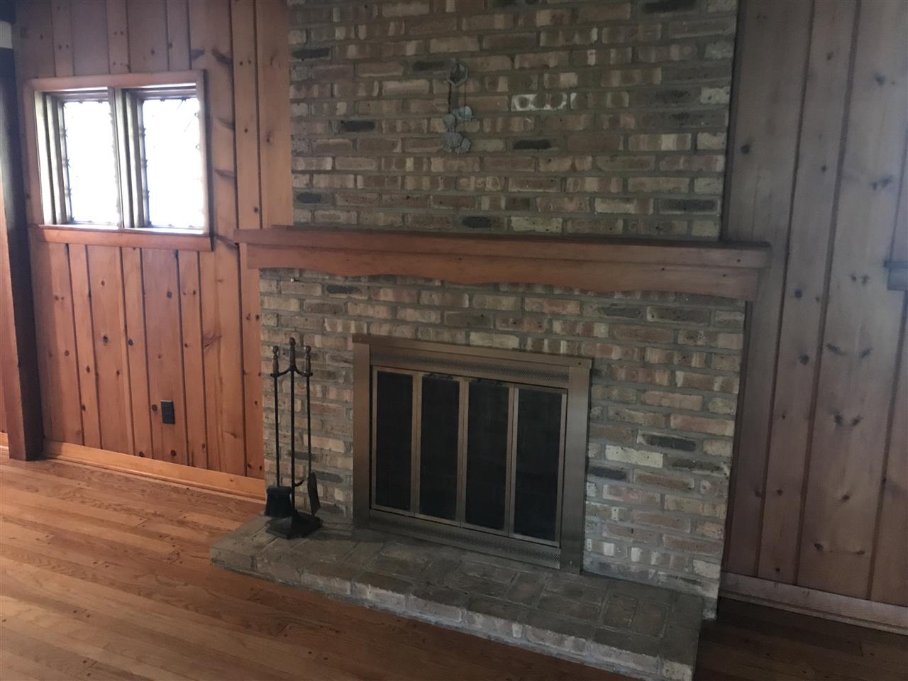 3727 Highcrest Road Rockford, IL 61107 - Photo 10 of 19 an empty room with wooden floor a fireplace and entryway