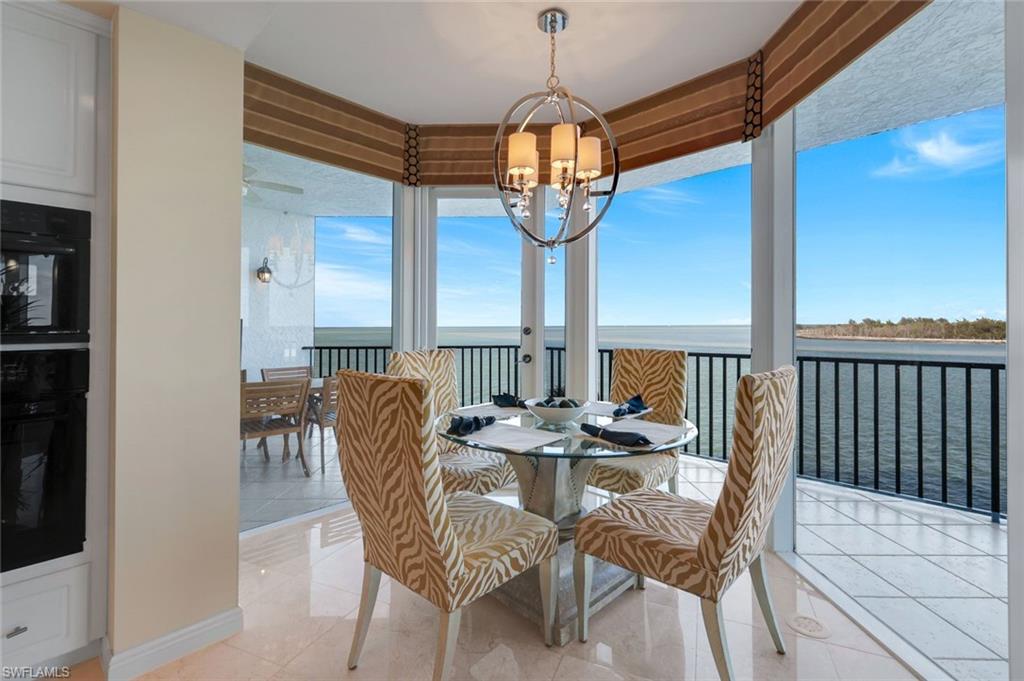 700 La Peninsula Boulevard, Unit 305 Naples, FL 34113 - Photo 13 of 39 a view of a dining room with furniture wooden floor and chandelier