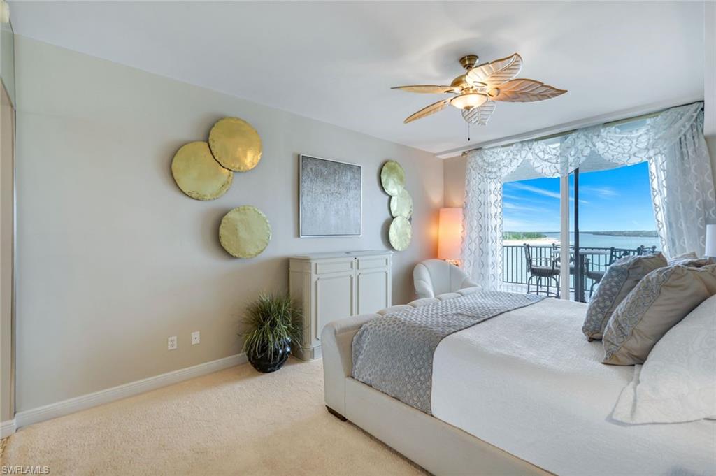 700 La Peninsula Boulevard, Unit 305 Naples, FL 34113 - Photo 21 of 39 a bedroom with a bed and a chandelier