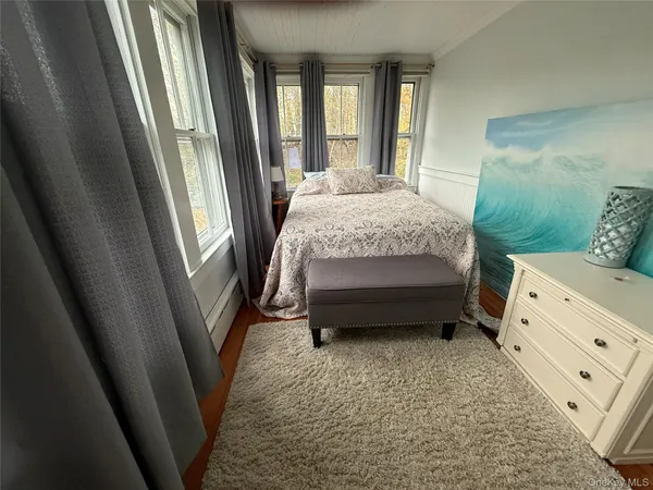 a bedroom with a bed next to a large window