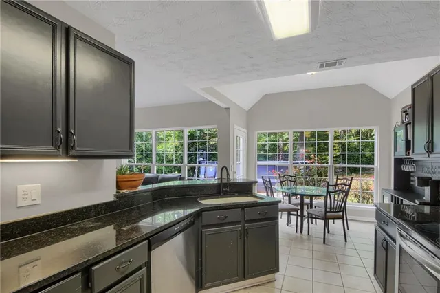 a kitchen with a sink and large windows