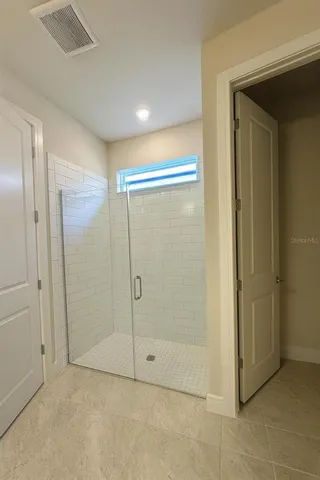 a bathroom with a shower and a glass door