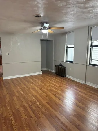 a view of empty room with wooden floor