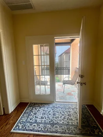 a view of a hallway with wooden floor and a rug