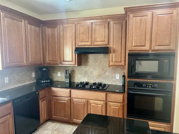 a kitchen with granite countertop cabinets stainless steel appliances and a window