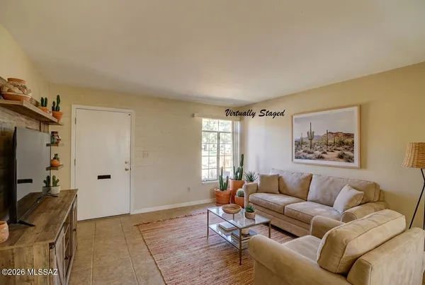 a living room with furniture a window and a flat screen tv