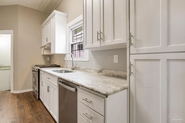 a kitchen with stainless steel appliances granite countertop a stove a refrigerator and a microwave