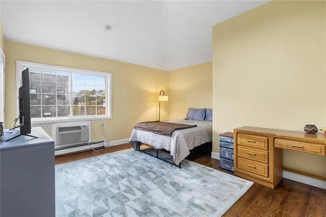 a spacious bedroom with a bed and wooden floor
