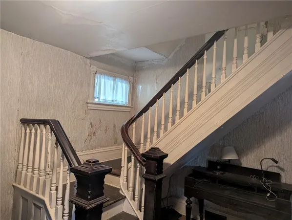 a view of entryway with wooden stairs and wooden floor