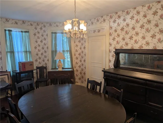 a living room with chairs and a chandelier