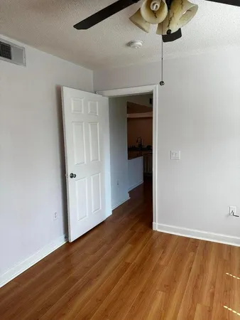 a view of empty room with wooden floor