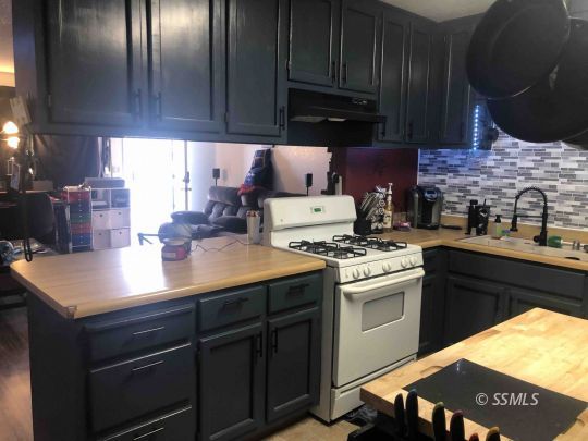 125 South Broadway Street Ridgecrest, CA 93555 - Photo 5 of 24 a kitchen with stainless steel appliances granite countertop a sink stove and refrigerator