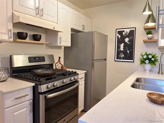 a kitchen with stainless steel appliances granite countertop a stove a refrigerator and a granite countertops with wooden floor