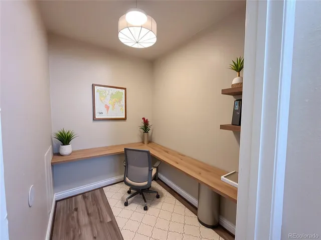 a view of a workspace with furniture and a window