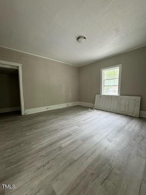 1615 Poole Road Raleigh, NC 27610 - Photo 11 of 14 an empty room with wooden floor and windows