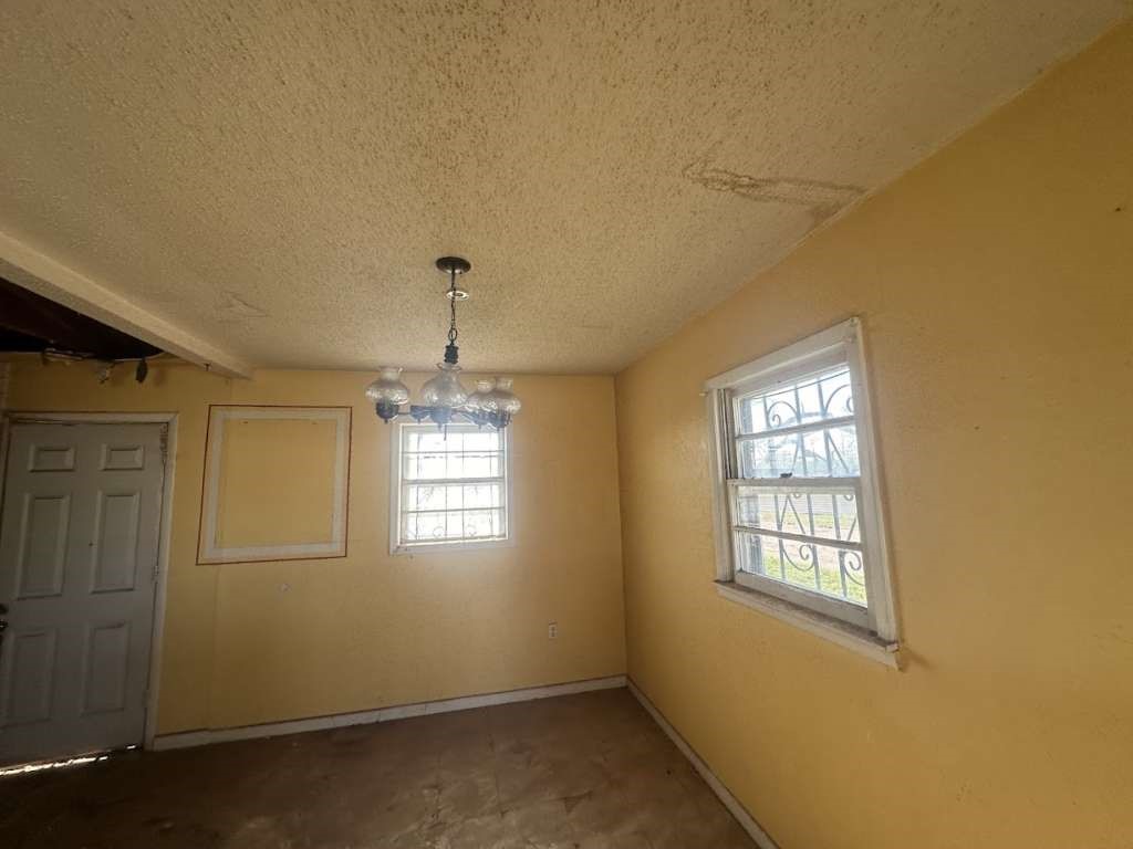 1909 Kokomo Street Plainview, TX 79072 - Photo 7 of 10 an empty room with windows and chandelier