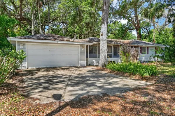 a front view of house with yard and trees around