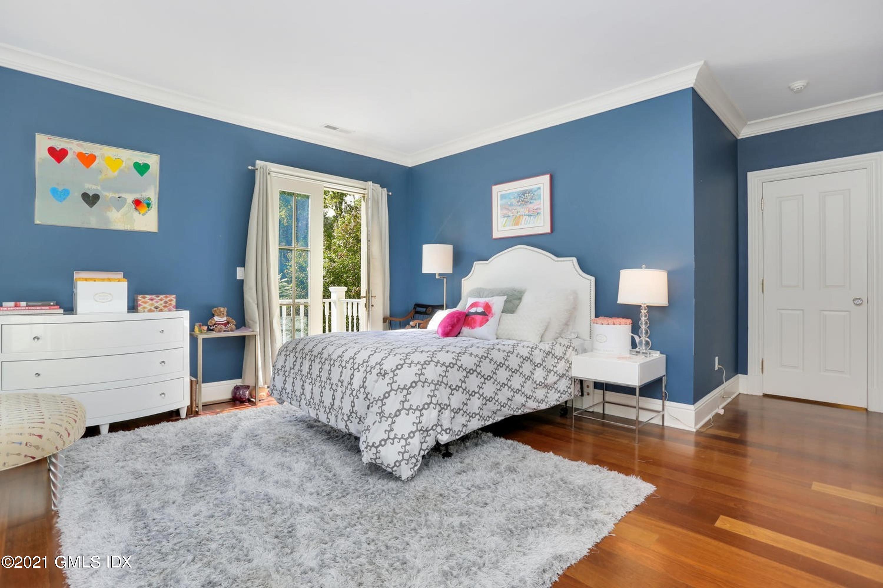477 Riversville Road Greenwich, CT 06831 - Photo 21 of 33 a bedroom with a bed and wooden floor