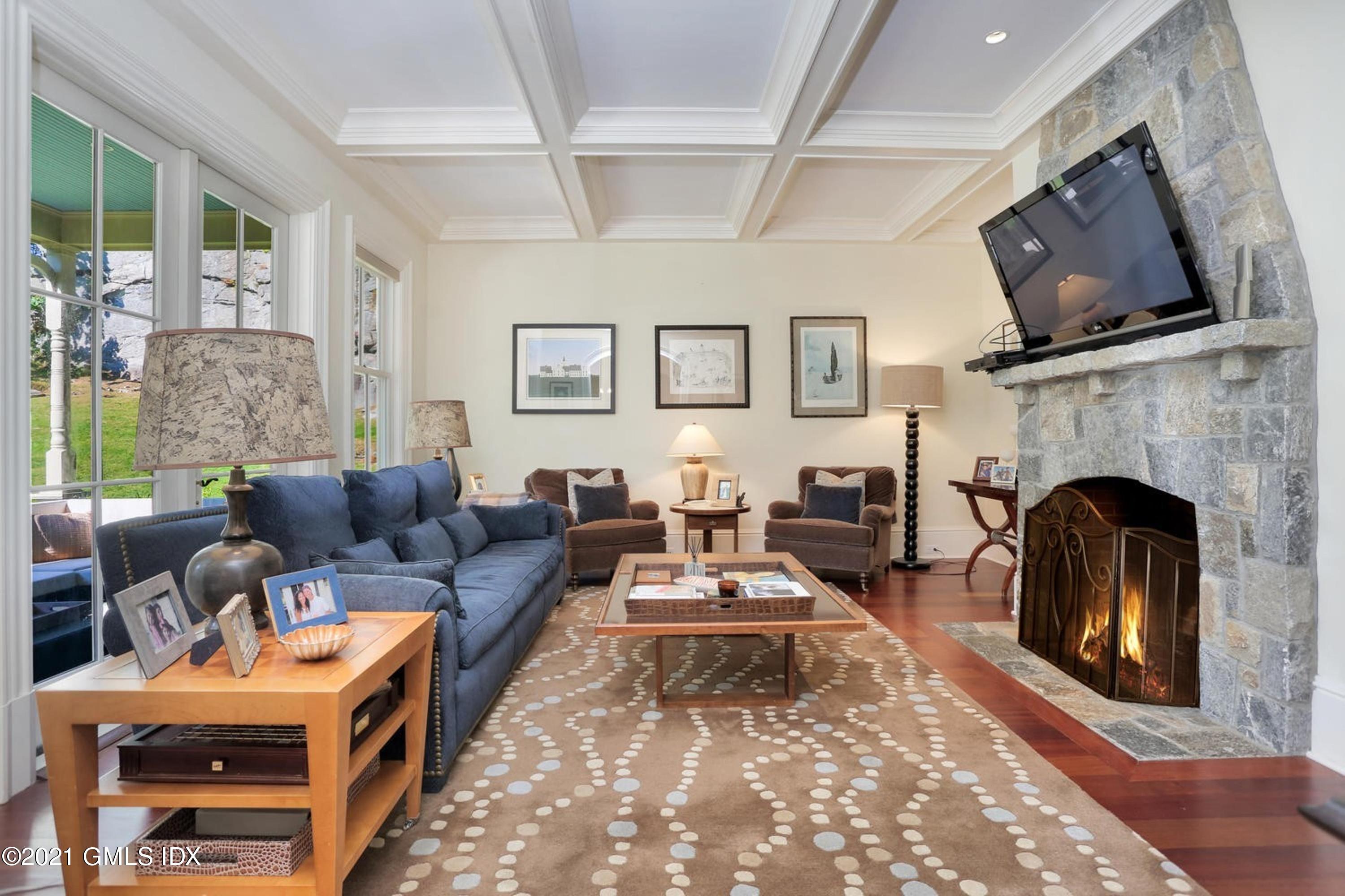 477 Riversville Road Greenwich, CT 06831 - Photo 9 of 33 a living room with furniture a flat screen tv and a fireplace