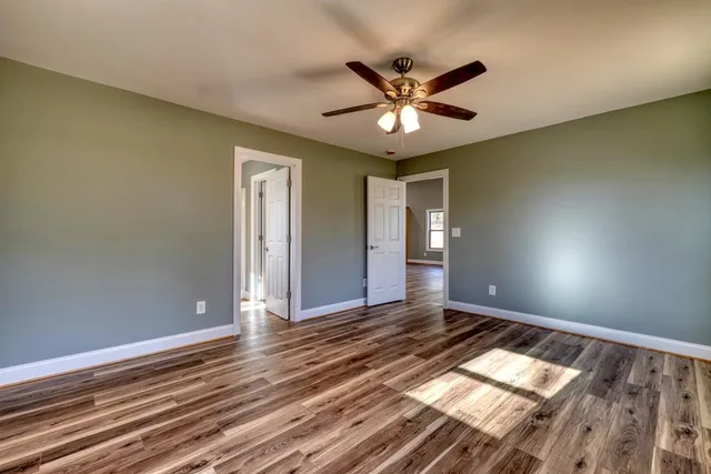 a view of an empty room and window and wooden floor