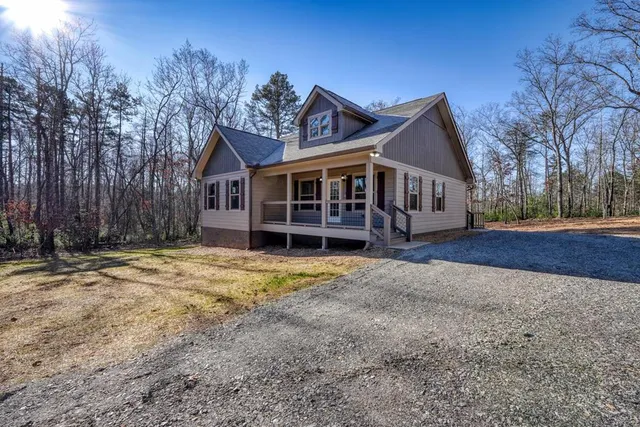 a view of a house with a yard and large tree