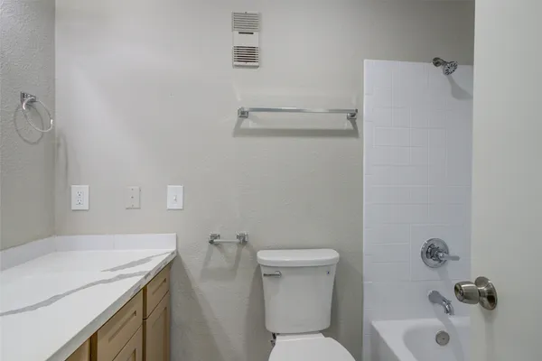 a bathroom with a sink vanity and a toilet