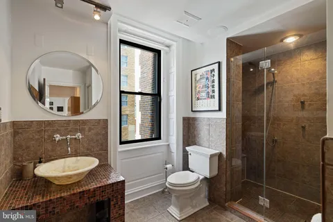 a bathroom with a toilet a sink and mirror