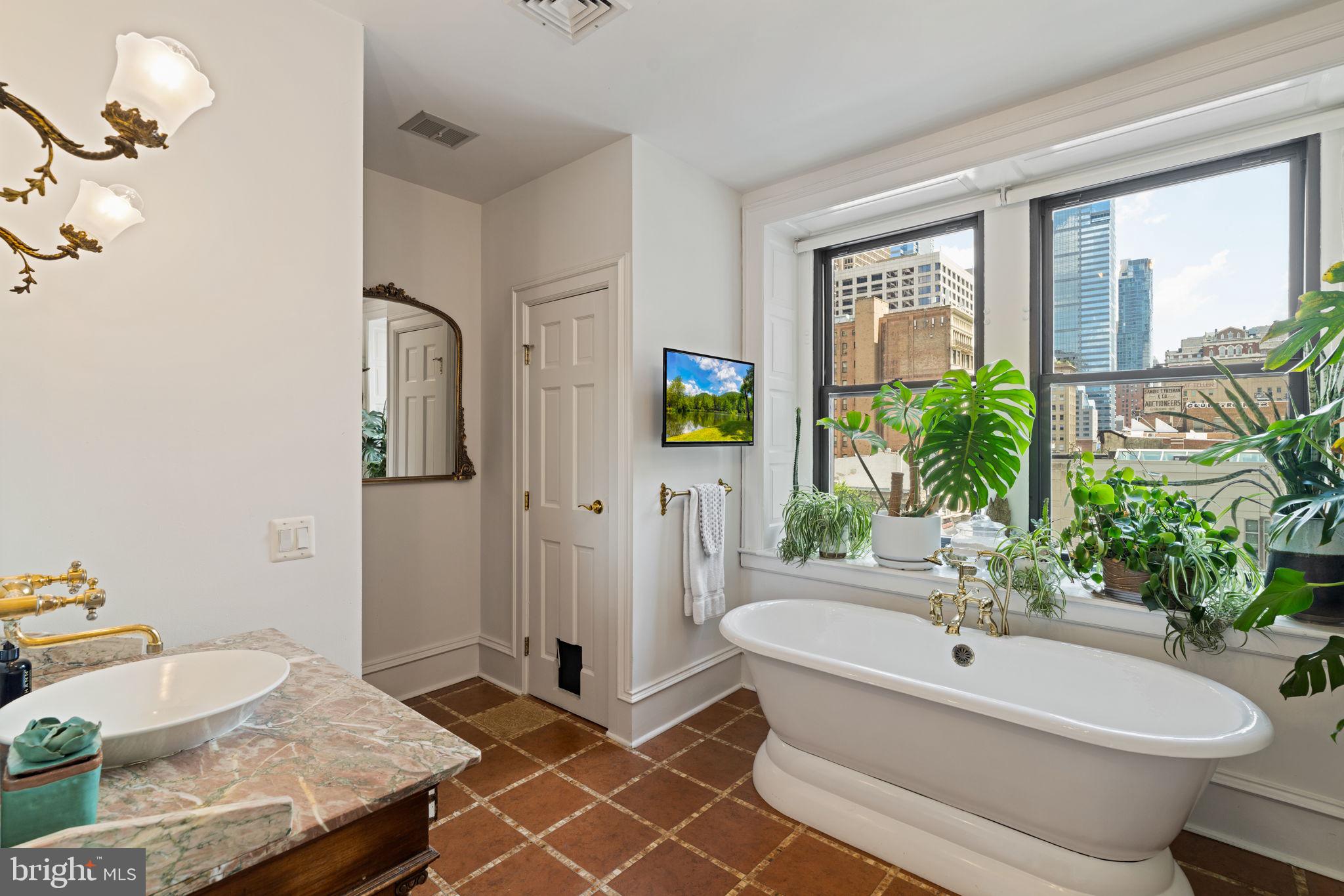 1920 Chestnut Street, Unit 5N Philadelphia, PA 19103 - Photo 25 of 33 a bathroom with a granite countertop sink and a mirror