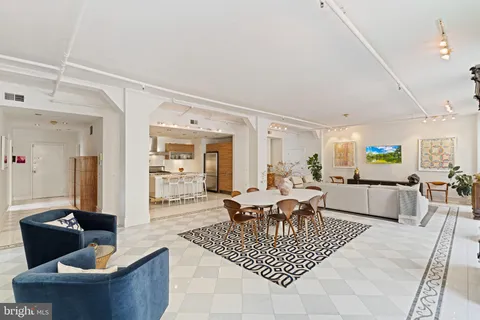 a living room with furniture a rug and a dining table