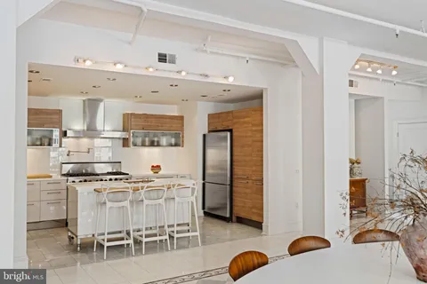 a kitchen with stainless steel appliances kitchen island granite countertop a table and chairs