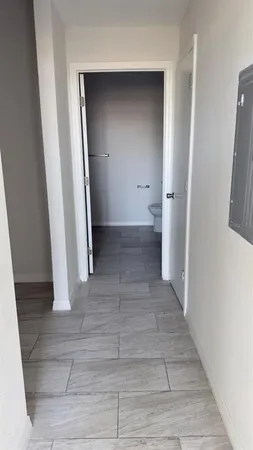 an empty room with wooden floor and entrance