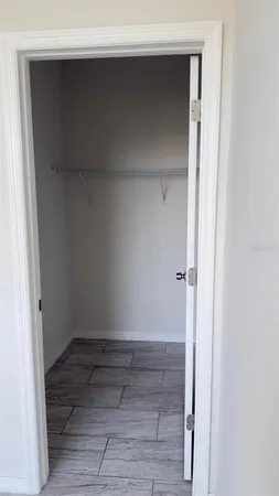 a view of walk in closet with empty racks