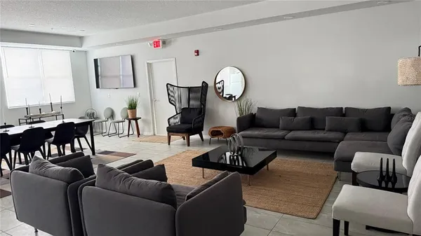 a living room with furniture a rug and a window