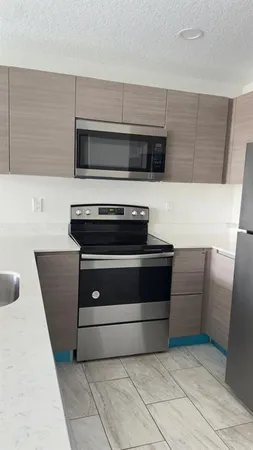 a kitchen with granite countertop a stove and a microwave